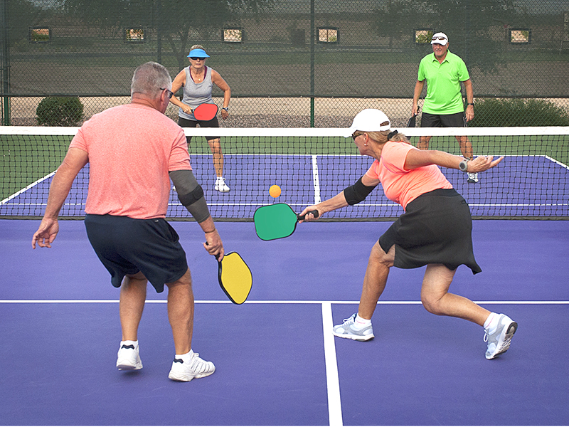 Colorful image of two teams playing Pickleball in a mixed doubles format.